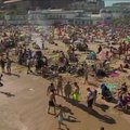 Jungtinės Karalystės paplūdimiuose – koronaviruso grėsmę pamiršę poilsiautojai