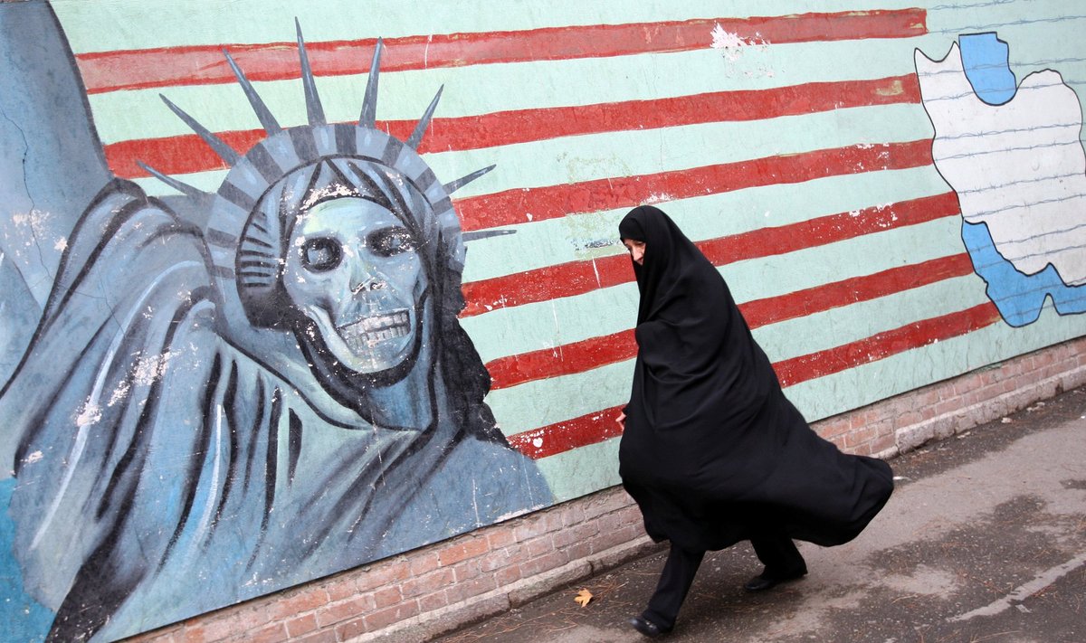 Iranietė Teherane eina po antiamerikietišką piešinį ant sienos.