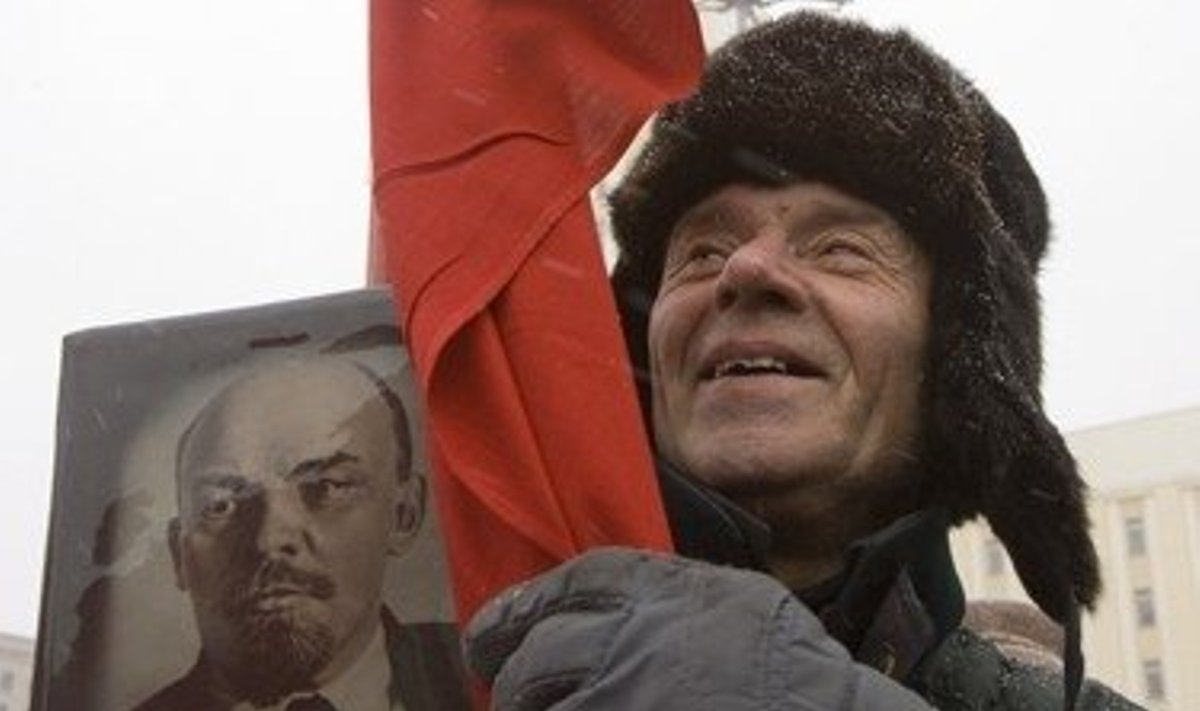 Vyras laiko Lenino portretą ir Sovietų vėliavą Minsko Nepriklausomybės aikštėje vykstančiame minėjime