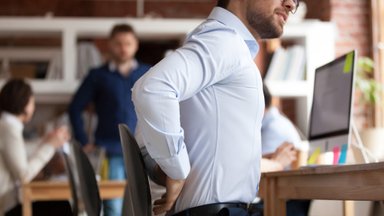 Nugaros ir kaklo skausmai – dažna sėdimą darbą dirbančių žmonių problema