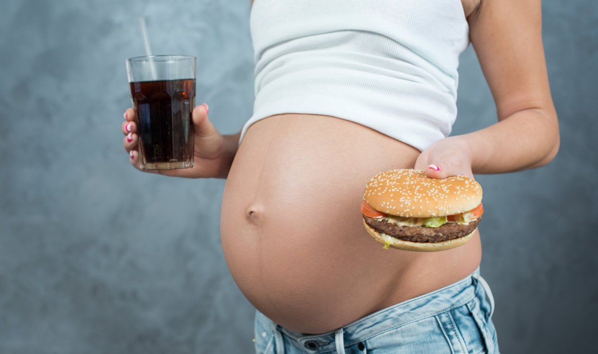 Nėščia moteris valgo greitąjį maistą