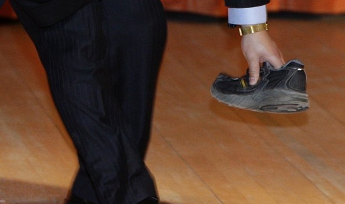 Apsaugininkas pakelia į  Wen Jiabao sviestą batą