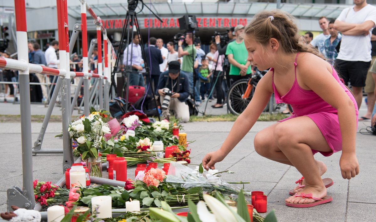 Mergaitė deda gėles šalia žudynių Miunchene vietos.