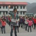 Kinijos kaimo moksleiviai rytinę mankštą atlieka pagal M. Jacksono muziką