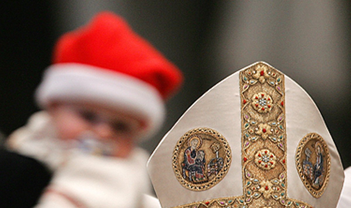 Šv.Petro Bazilikoje vykstančiose mišiose Naujųjų Metų dieną Popiežius Benediktas XVI žiūri į kūdikį, papuoštą Kalėdų Senelio kepure. 